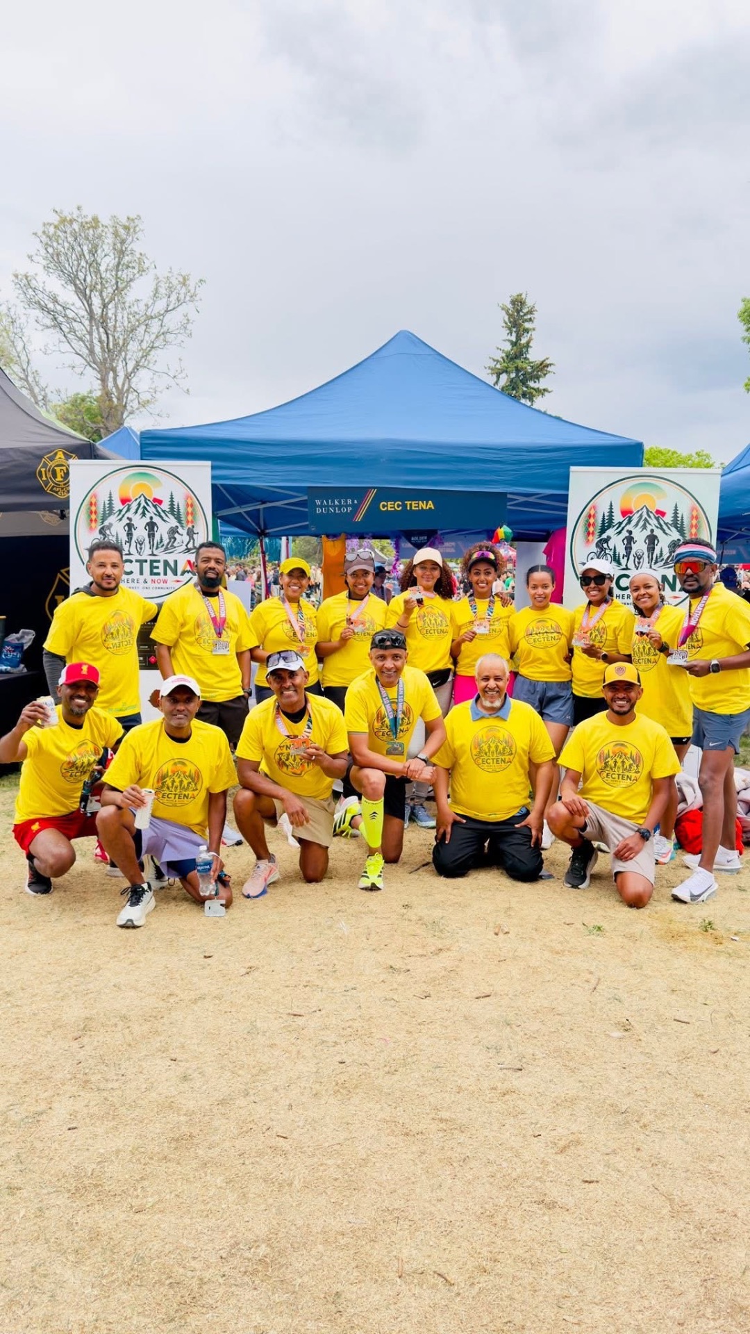 Large group of CECTENA members in yellow shirts at a community event